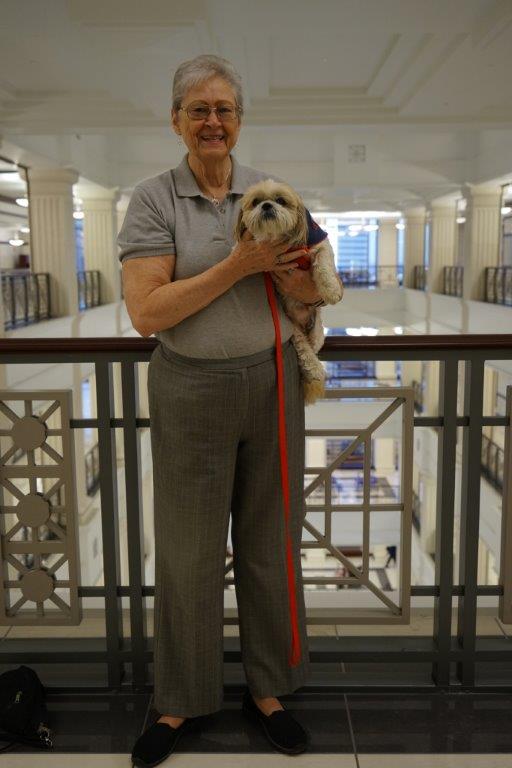 A woman holds a Pekinese dog in the courthouse second floor 